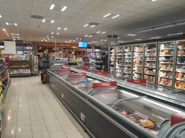 Zeigt die Werbedisplays im Rewe-Kassenbereich